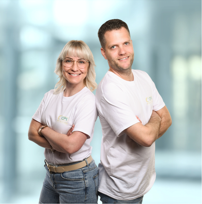 Carolin und Pascal Störmer stehen Rücken an Rücken und lächeln in die Kamera.