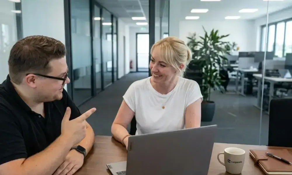 Strategische Positionierung von Caro bei der Beratung eines Kunden am Laptop